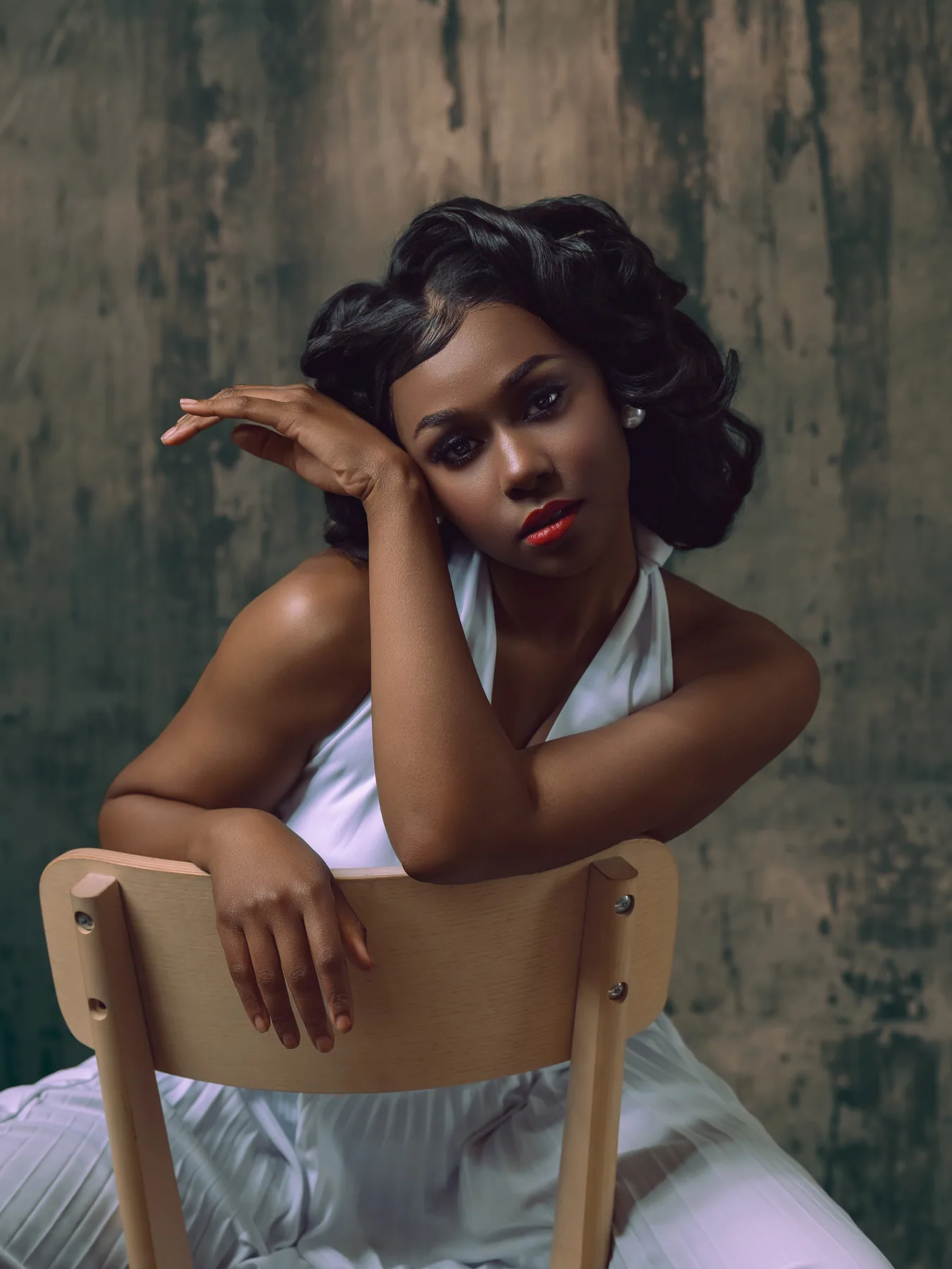 Editorial portrait with smoky eye makeup, red lips, sculpted waves, and pearl earrings