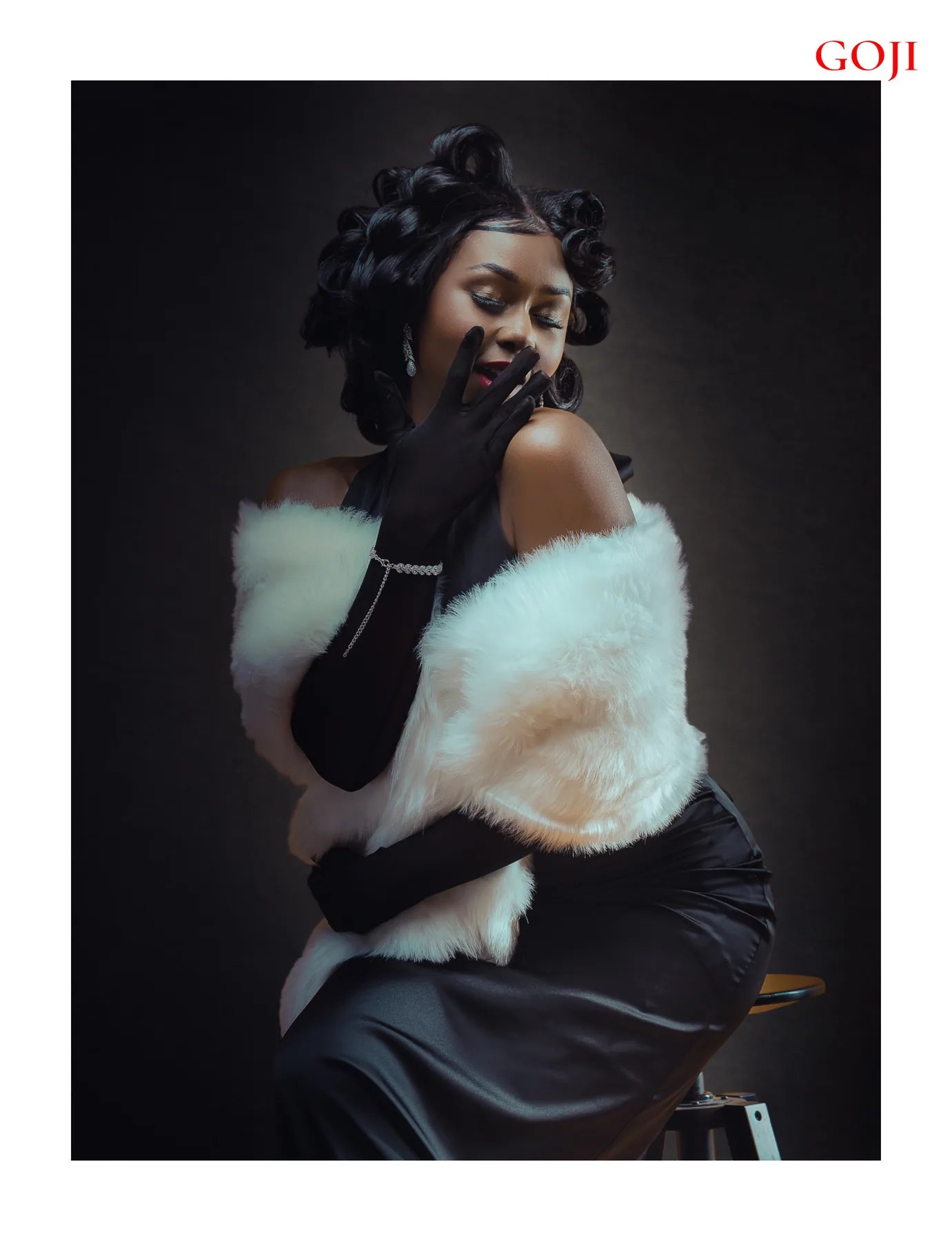 GOJI published portrait of a model in satin, pearls, long black gloves, and a pale stole